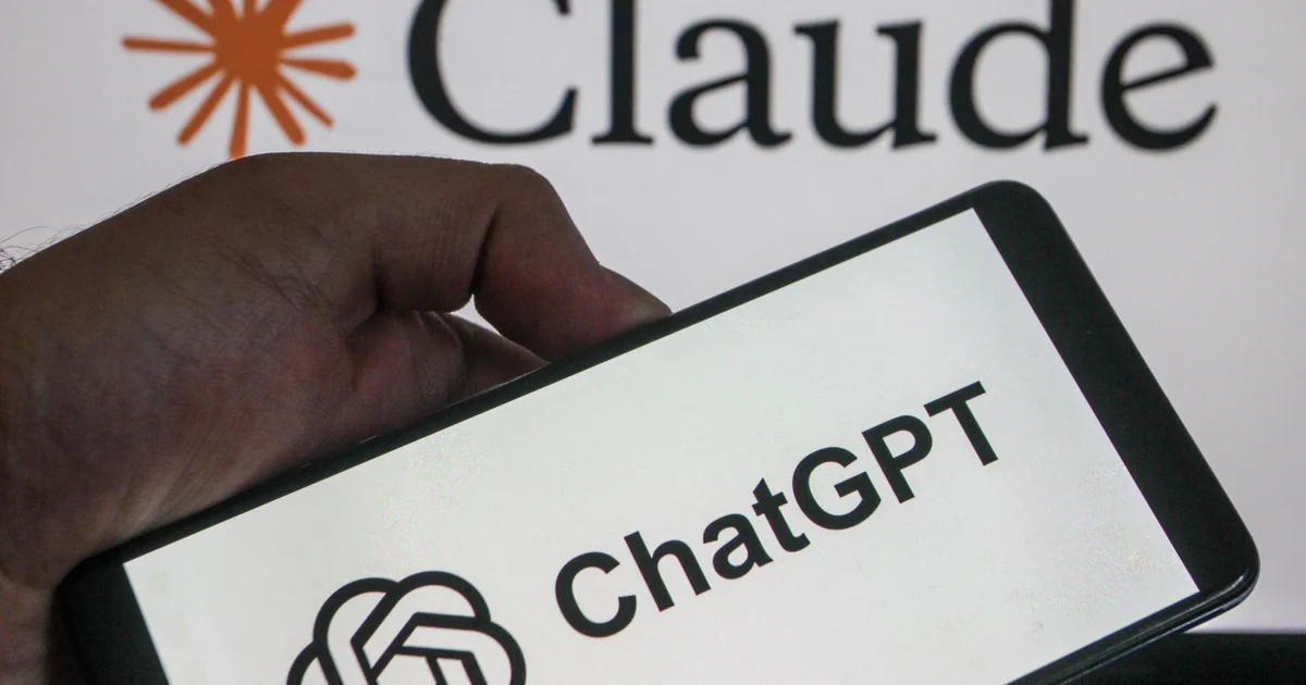 A hand holding a smartphone displaying the ChatGPT logo in front of a screen showing the Claude logo
