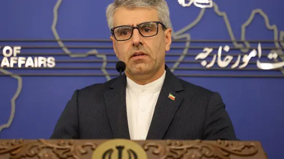 Iranian Foreign Ministry spokesperson Esmaeil Baghaei speaking at a podium during a press briefing