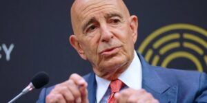 Tom Barrack gesturing while speaking into a microphone