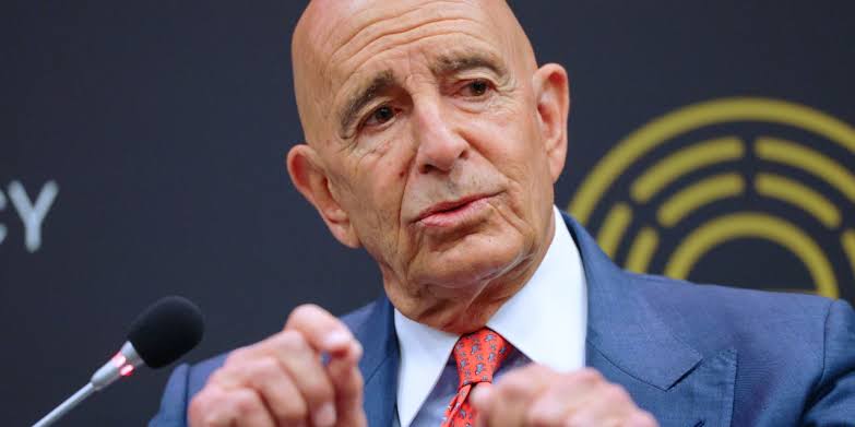 Tom Barrack gesturing while speaking into a microphone