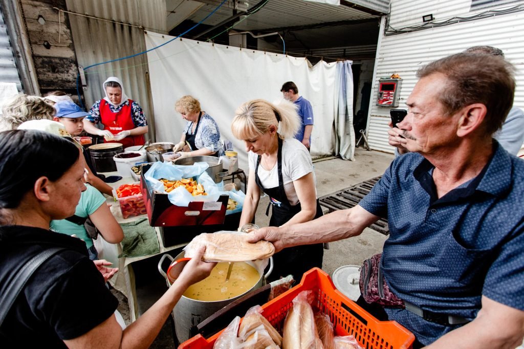 Volunteers serve food to a community in Kharkiv