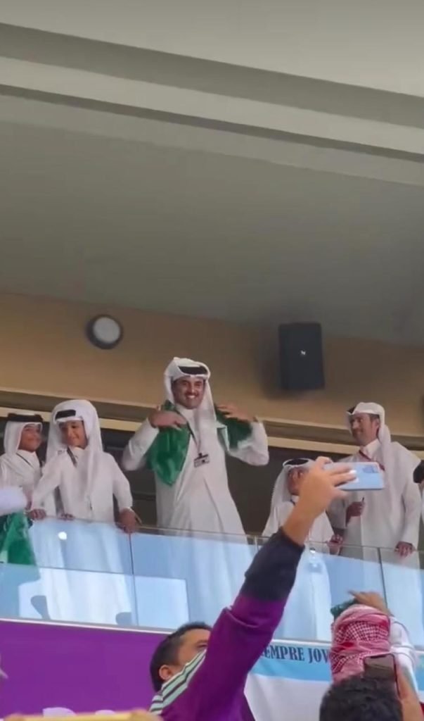Qatar's Emir wearing the Saudi flag around his neck.