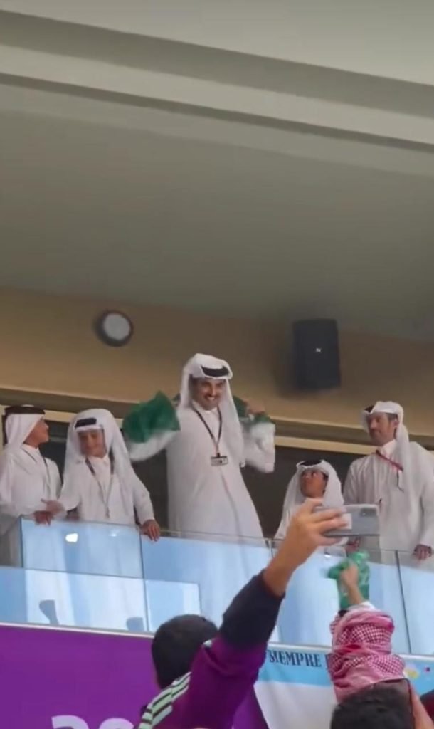 Qatar's Emir wearing the Saudi flag around his neck.
