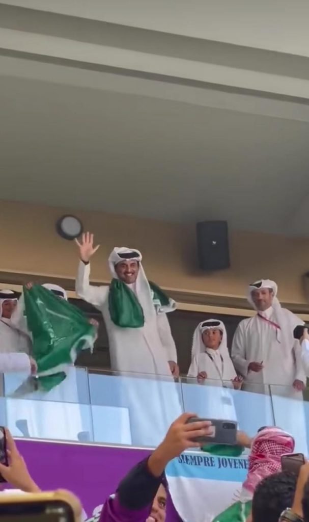 Qatar's Emir wearing the Saudi flag around his neck.