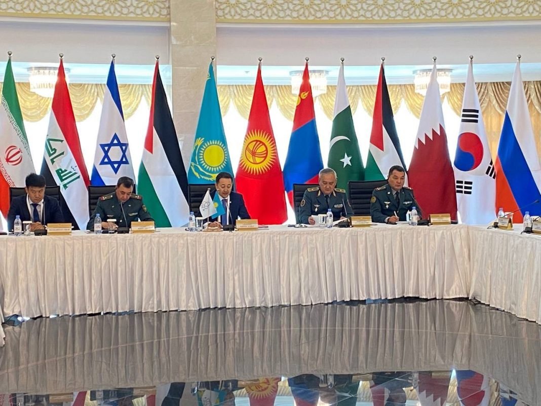 Defense officials and military attachés discussing cooperation and security at the CICA military-political dimension development seminar.