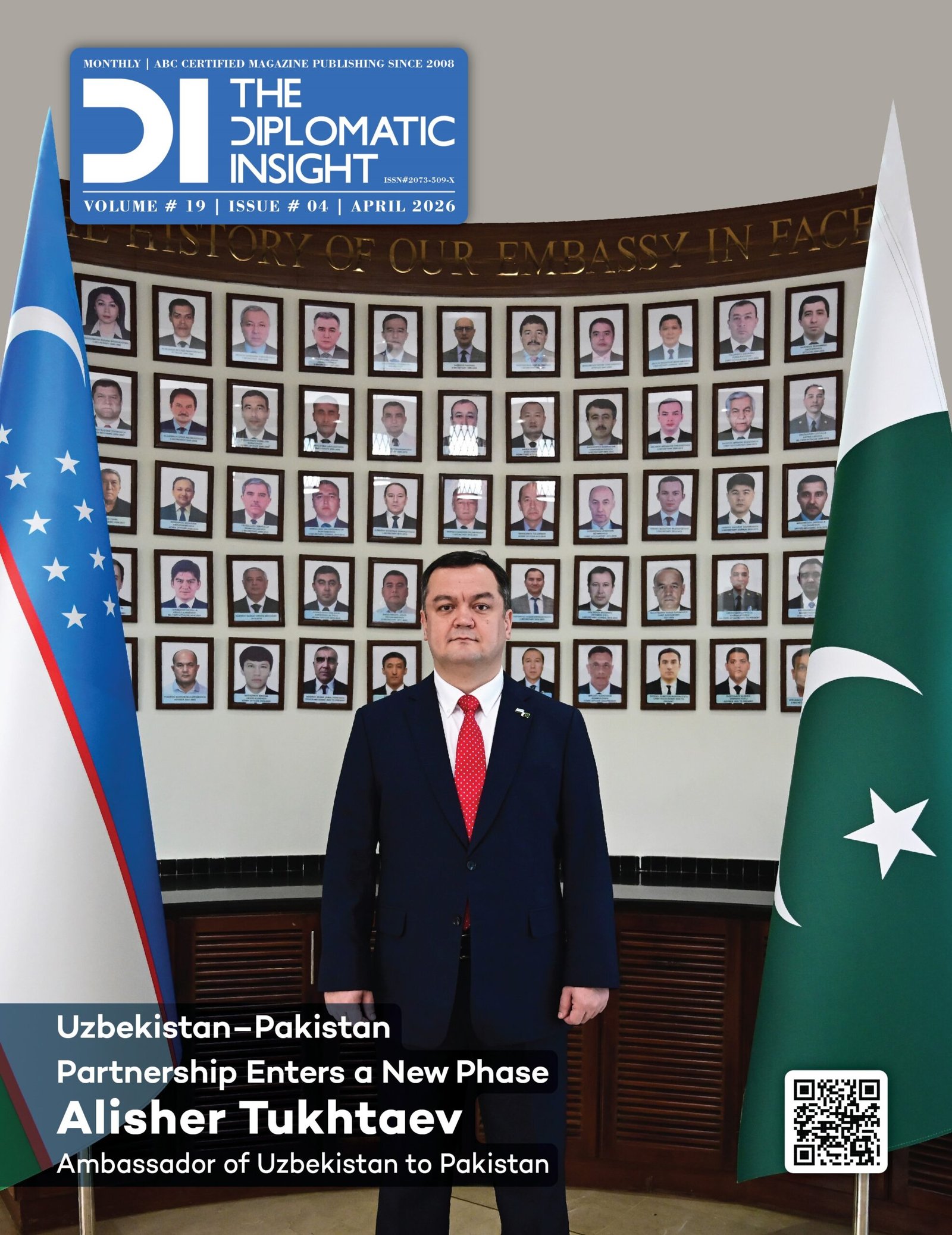 This image is the front cover of the April 2026 issue of The Diplomatic Insight magazine (Volume 19, Issue 04). The cover features a formal portrait of Alisher Tukhtaev, the Ambassador of Uzbekistan to Pakistan, standing centrally between the national flags of Uzbekistan (left) and Pakistan (right). He is wearing a dark navy suit with a bright red tie. Behind the Ambassador is a large, curved wall display featuring dozens of framed portraits of individuals, arranged in a grid pattern. Above the portraits, a gold inscription on the wall reads, "...THE HISTORY OF OUR EMBASSY IN FACE...".