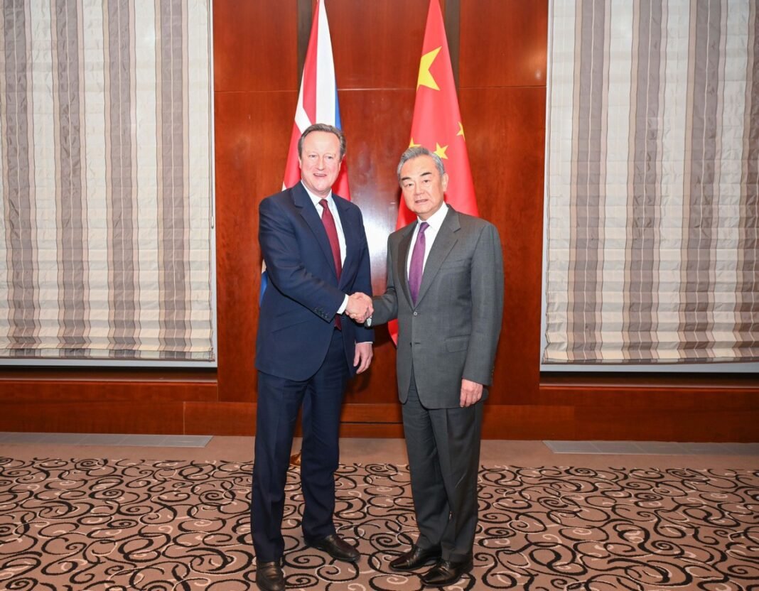 Foreign Minister Wang Yi, also a member of the Political Bureau of the Communist Party of China Central Committee, shakes hands with British Foreign Secretary David Cameron during their meeting on the sidelines of the Munich Security Conference in Munich, Germany, on Feb 16, 2024.